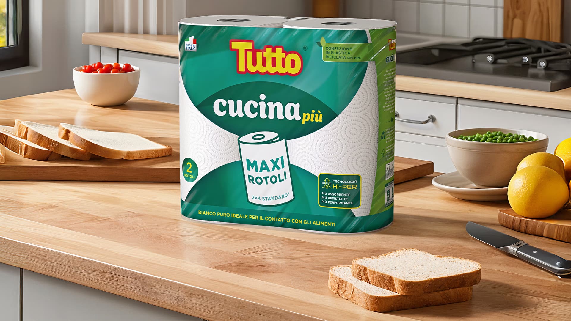 Confezione di rotoli da cucina Tutto Cucina Più su un piano di legno, accanto a fette di pane