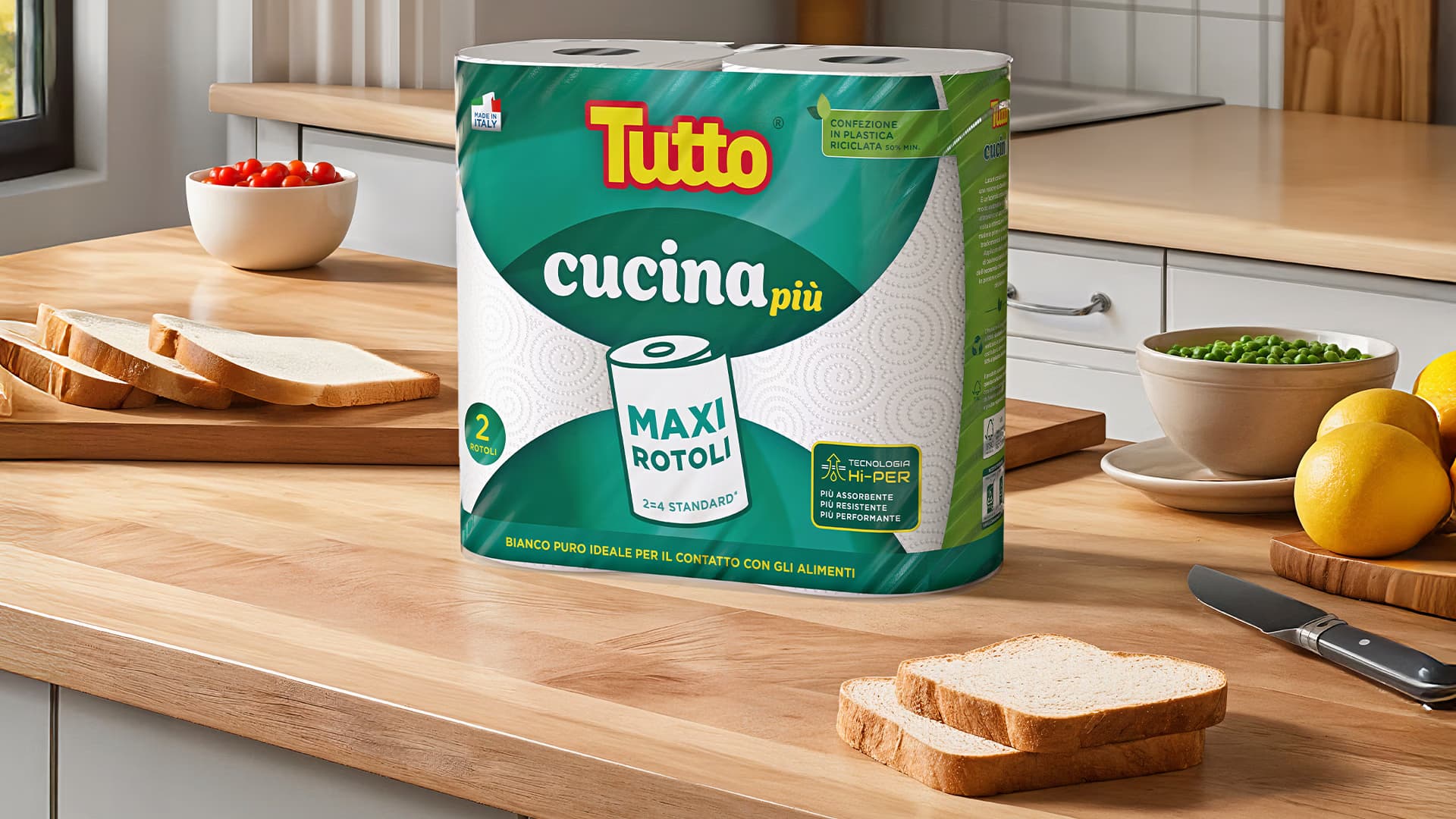Confezione di rotoli da cucina Tutto Cucina Più su un piano di legno, accanto a fette di pane
